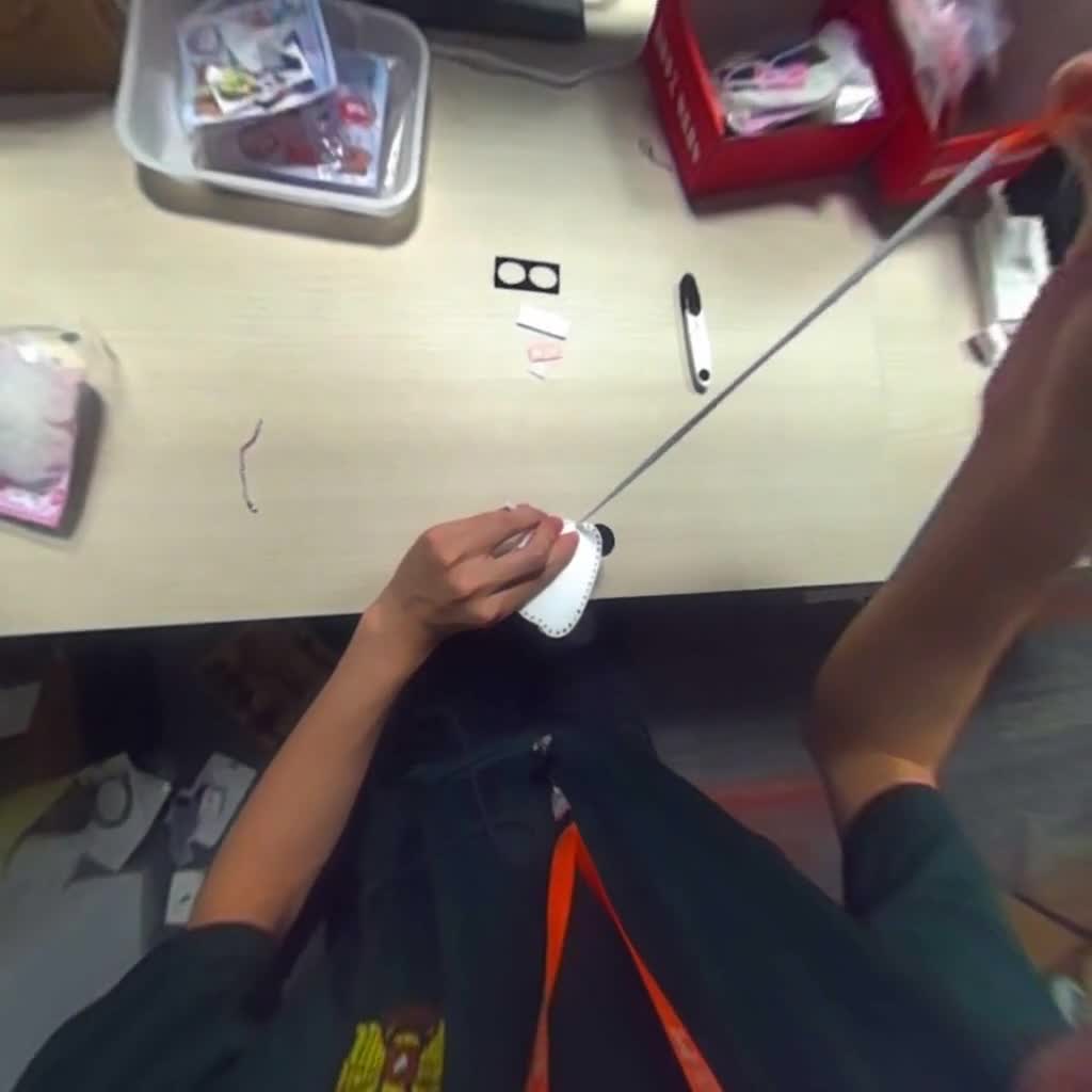 First-person craft scene sewing a plush object