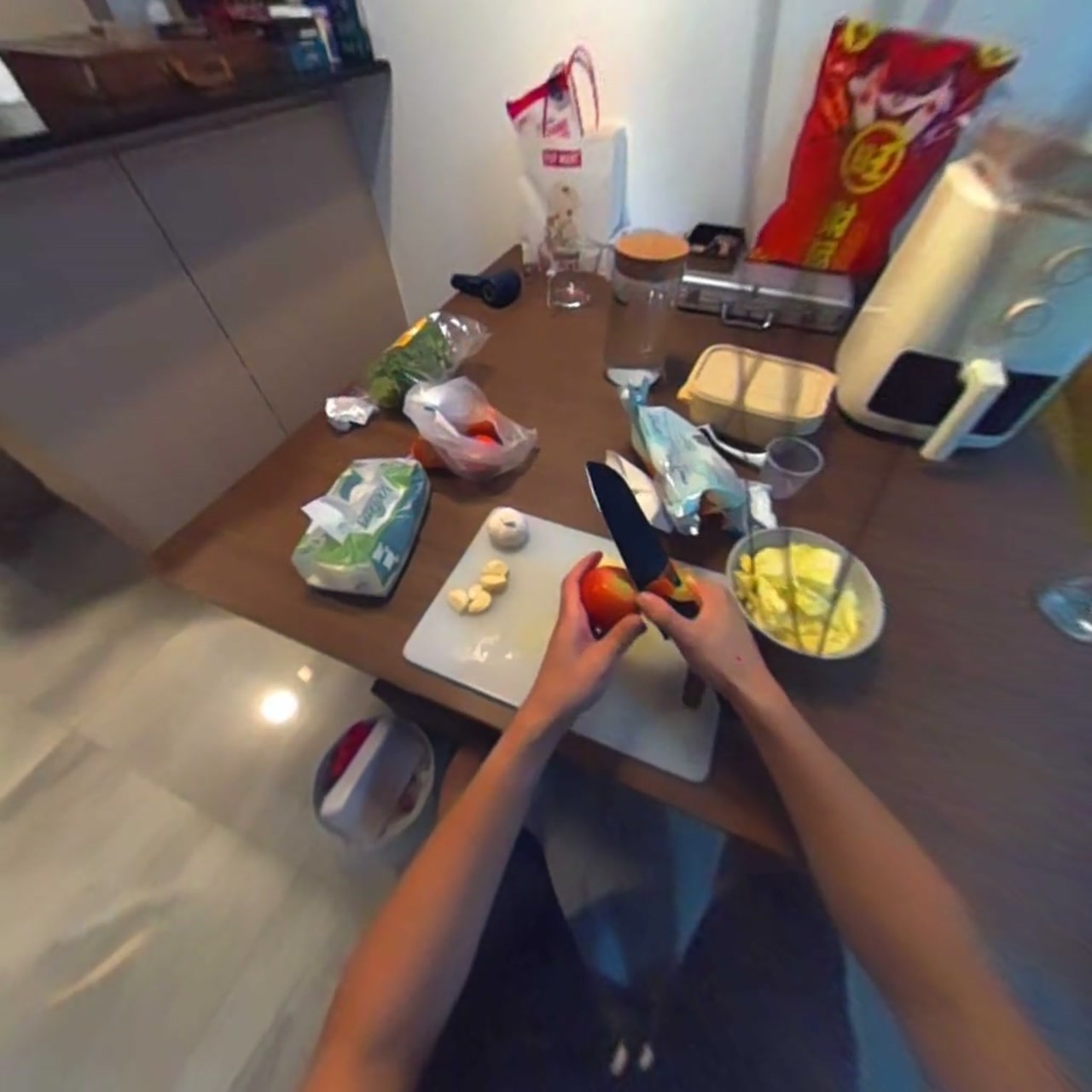 First-person kitchen scene with a knife and cutting board